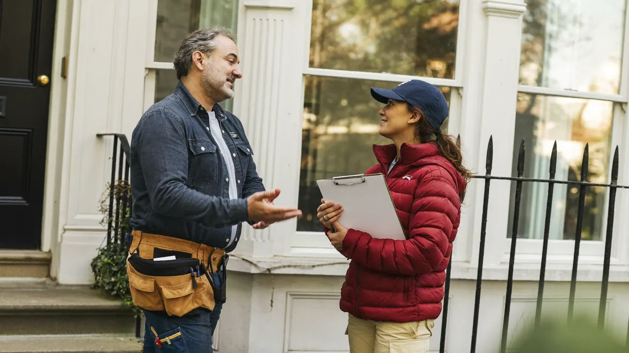 Homeowner asking a window installer questions on the doorstep before a survey