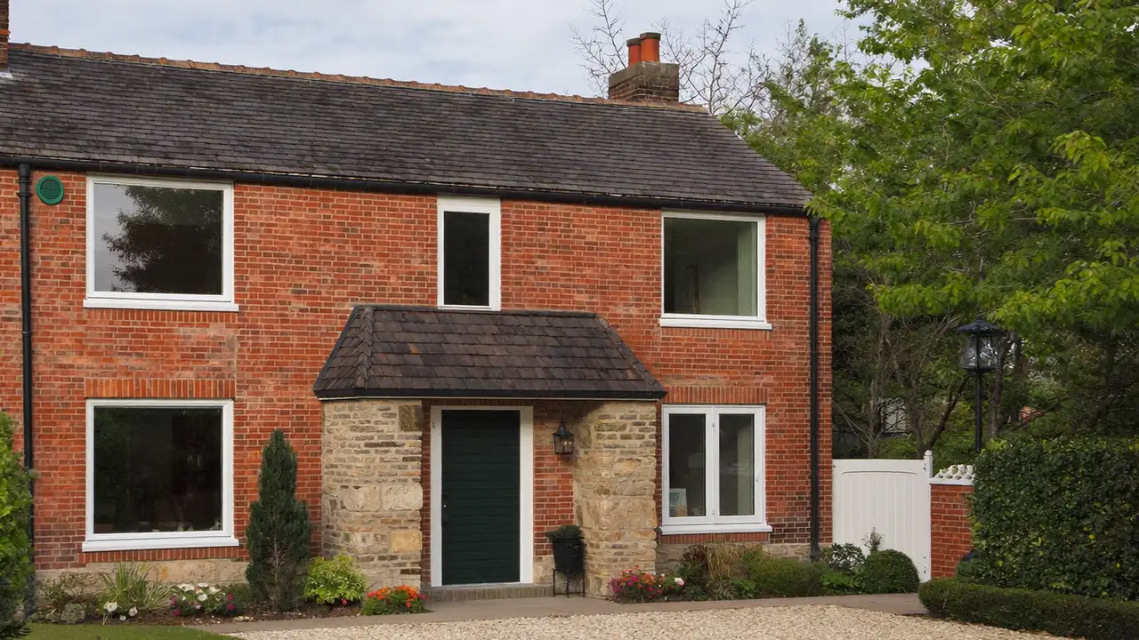 Semi-detached house with white double glazed windows across the front elevation